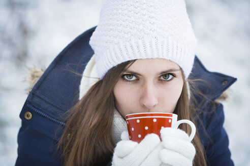 Portrait of young woman with cup in winter - JTLF000046