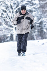 Germany, Baden-Wuerttemberg, Holzberg, senior man jogging in snow - STSF000686