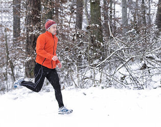 Deutschland, Baden-Württemberg, Holzberg, Mann joggt im Schnee - STSF000688