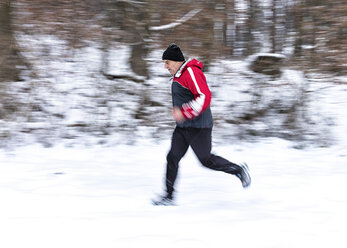 Deutschland, Baden-Württemberg, Holzberg, älterer Mann joggt im Schnee - STSF000689