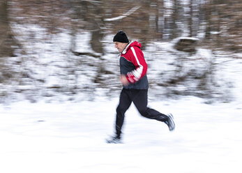 Germany, Baden-Wuerttemberg, Holzberg, senior man jogging in snow - STSF000689