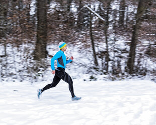 Germany, Baden-Wuerttemberg, Holzberg, man jogging in snow - STSF000690