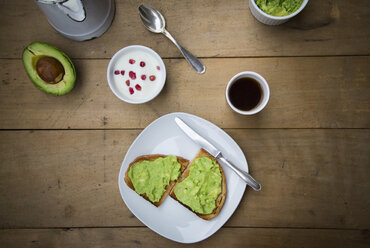 Brot mit Avocadocreme, Joghurt mit Granatapfelkernen und eine Tasse Kaffee - LVF002656