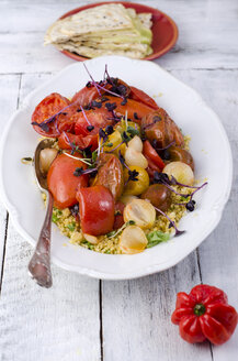 Couscous-Salat mit gedünsteter Tomate, Knoblauch und Kresse auf dem Teller - ODF001078