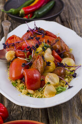 Couscous-Salat mit gedünsteter Tomate, Knoblauch und Kresse auf dem Teller - ODF001079