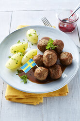 Koettbullar, schwedische Fleischbällchen mit Kartoffeln und Soße auf einem Teller, Preiselbeeren - KSWF001352
