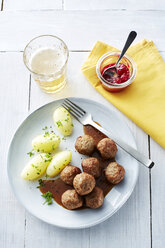 Koettbullar, schwedische Fleischbällchen mit Kartoffeln und Soße auf einem Teller, Preiselbeeren - KSWF001354