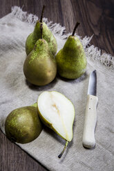 Whole and sliced pears and a kitchen knife on cloth - SARF001290