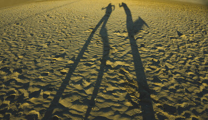 Spain, Valencia, shadow play of two persong on the beach - UUF003201