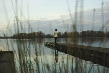 Deutschland, Roxheim, Frau auf Holzpromenade am Wasser stehend - UUF003093