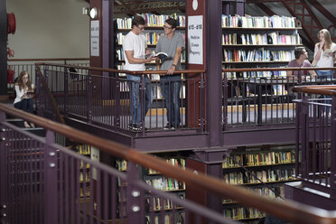 Studenten in einer Bibliothek, die sich Bücher ansehen - ZEF004245