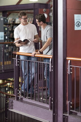 Zwei Studenten unterhalten sich in einer Bibliothek - ZEF004248