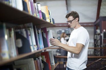 Studentin auf der Suche nach Büchern in einer Bibliothek - ZEF004252