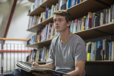 Student mit digitalem Tablet und Kopfhörern in einer Bibliothek - ZEF004347