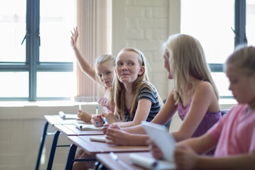 Schoolgirl in classroom raising her hand - ZEF004949