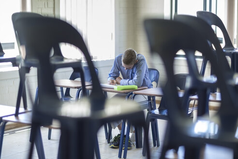 Schuljunge schreibt im Klassenzimmer - ZEF004952