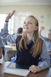 Schulmädchen im Klassenzimmer hebt ihre Hand - ZEF004964