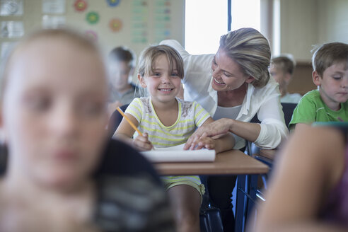 Lächelnde Lehrerin und Schülerin im Klassenzimmer - ZEF004986