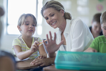 Schülerin zählt die Finger des Lehrers im Klassenzimmer - ZEF004990