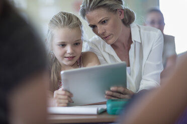 Lehrerin und Schülerin mit digitalem Tablet im Klassenzimmer - ZEF004992