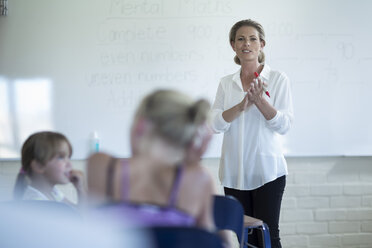 Lehrer im Klassenzimmer, der am Whiteboard spricht - ZEF004998