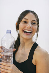 Portrait of laughing woman with water bottle - EBSF000420