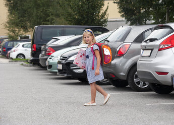 Kleines Mädchen auf dem Schulweg beim Überqueren des Parkplatzes - WWF003670