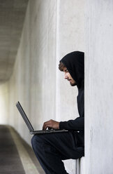 Hacker mit Laptop in einer Tiefgarage - WWF003641