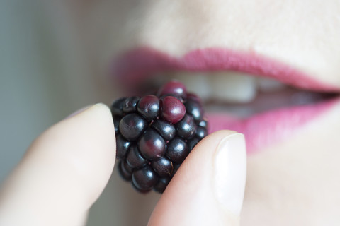 Woman's fingers holding blackberry stock photo