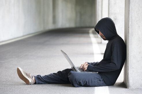 Hacker mit Laptop in einer Tiefgarage - WWF003672