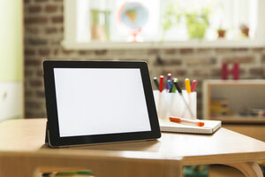 Tablet computer on wooden table in children's room - MFF001405