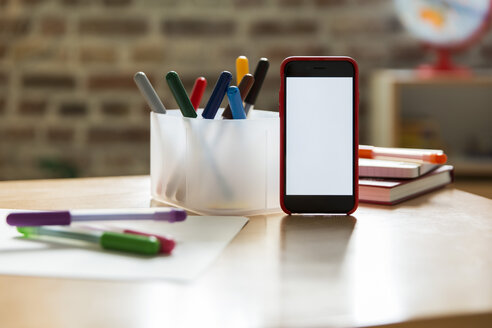 Smartphone auf Holztisch im Kinderzimmer - MFF001410