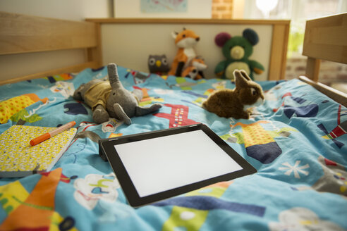 Tablet-Computer und Kuscheltiere auf dem Bett im Kinderzimmer - MFF001411