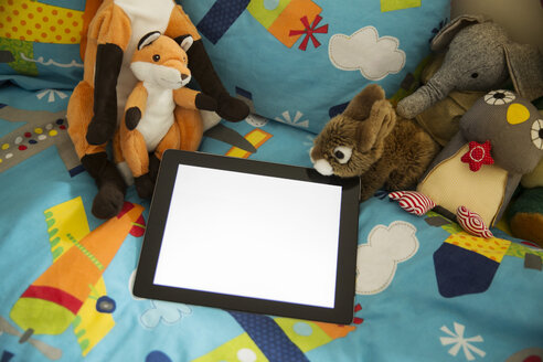 Tablet-Computer und Kuscheltiere auf dem Bett im Kinderzimmer - MFF001412