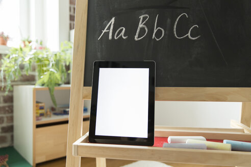 Tablet-Computer an die Tafel im Kinderzimmer gelehnt - MFF001414
