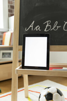 Tablet-Computer an die Tafel im Kinderzimmer gelehnt - MFF001420