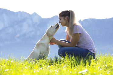 Österreich, Mondsee, Frau mit Labrador Retriever auf Almwiese - WWF003741