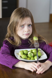 Unhappy little girl with plate of Brussels sprouts - SARF001297
