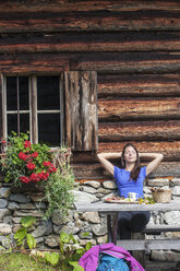 Austria, Altenmarkt-Zauchensee, young woman realxing at alpine cabin - HHF005069