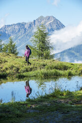 Österreich, Altenmarkt-Zauchensee, junge Frau beim Wandern in alpiner Landschaft - HHF005071