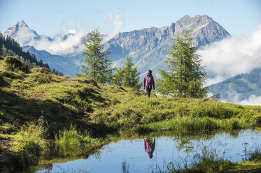 Österreich, Altenmarkt-Zauchensee, junge Frau beim Wandern in alpiner Landschaft - HHF005072