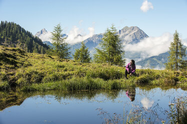 Österreich, Altenmarkt-Zauchensee, junge Frau beim Wandern in alpiner Landschaft - HHF005073