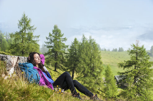 Österreich, Altenmarkt-Zauchensee, junge Frau auf Almwiese liegend - HHF005075