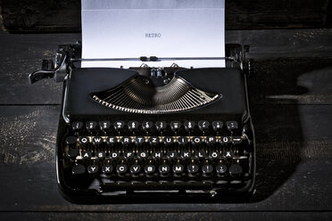 Old black typewriter on dark wood - MAEF009493