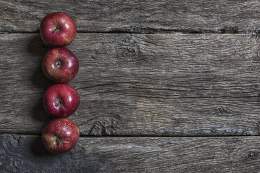 Vier rote Äpfel auf dunklem Holz - MGOF000038