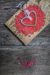 Metal heart with pink jelly on wooden chopping board - MGOF000049