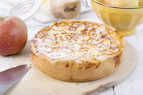 Selbstgebackener Apfelkuchen mit gehobelten Mandeln und Puderzucker, lizenzfreies Stockfoto