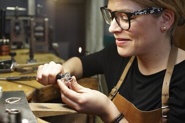 Goldschmied in der Werkstatt bei der Bearbeitung eines herzförmigen Schmuckstücks - EDF000105