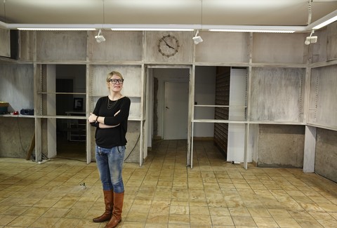 Frau steht in leerem Laden, lizenzfreies Stockfoto