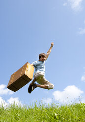 Junger Mann mit Koffer springt in die Luft - WWF003681